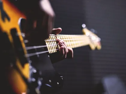 person-playing-sun-burst-electric-bass-guitar-in-bokeh-96380.jpg